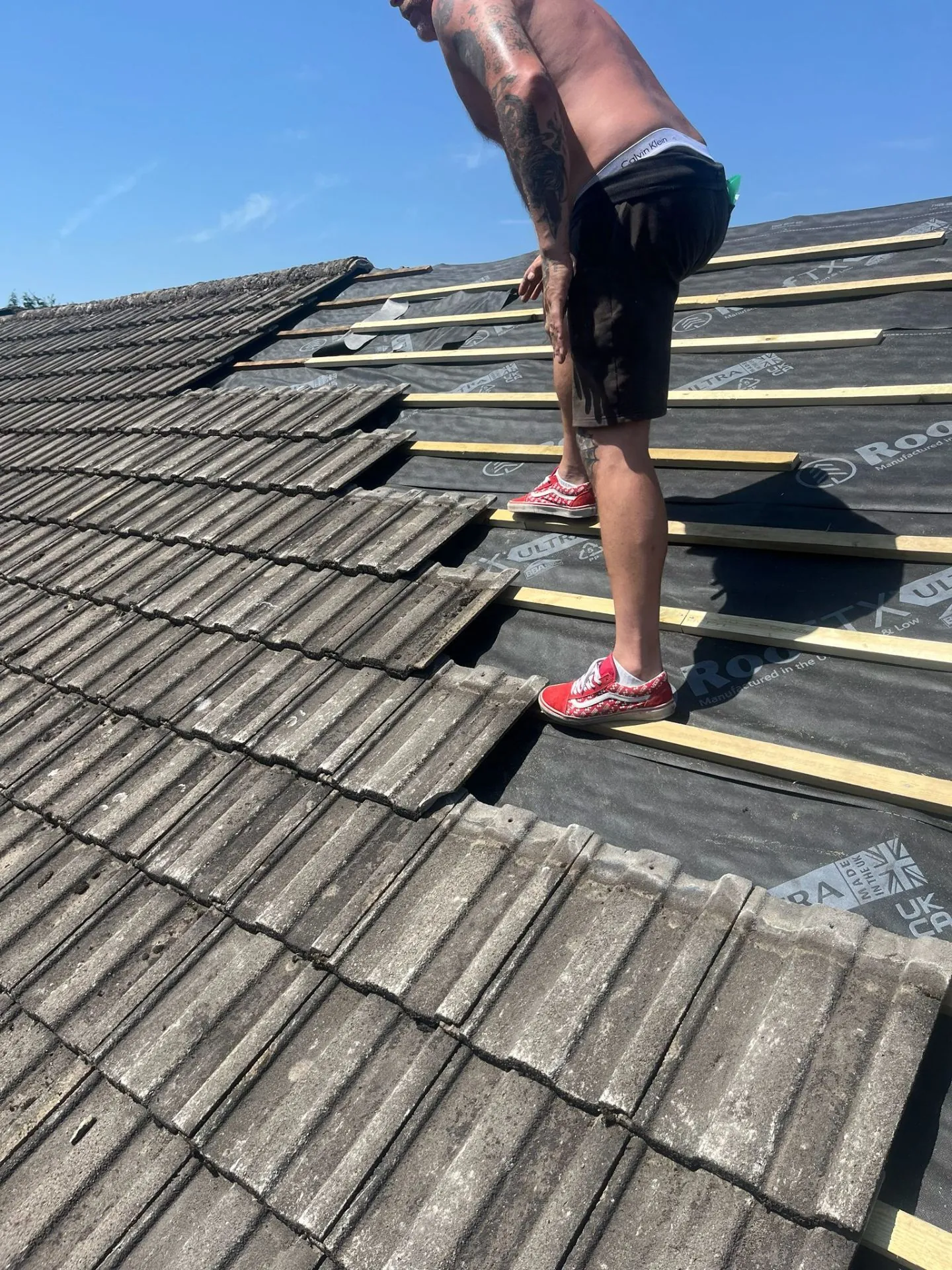 Stripping tiles ready for re-felt and batten